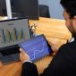 A man Using Tab and system to check Why UK/US Companies Are Investing in BI Development Now More Than Ever